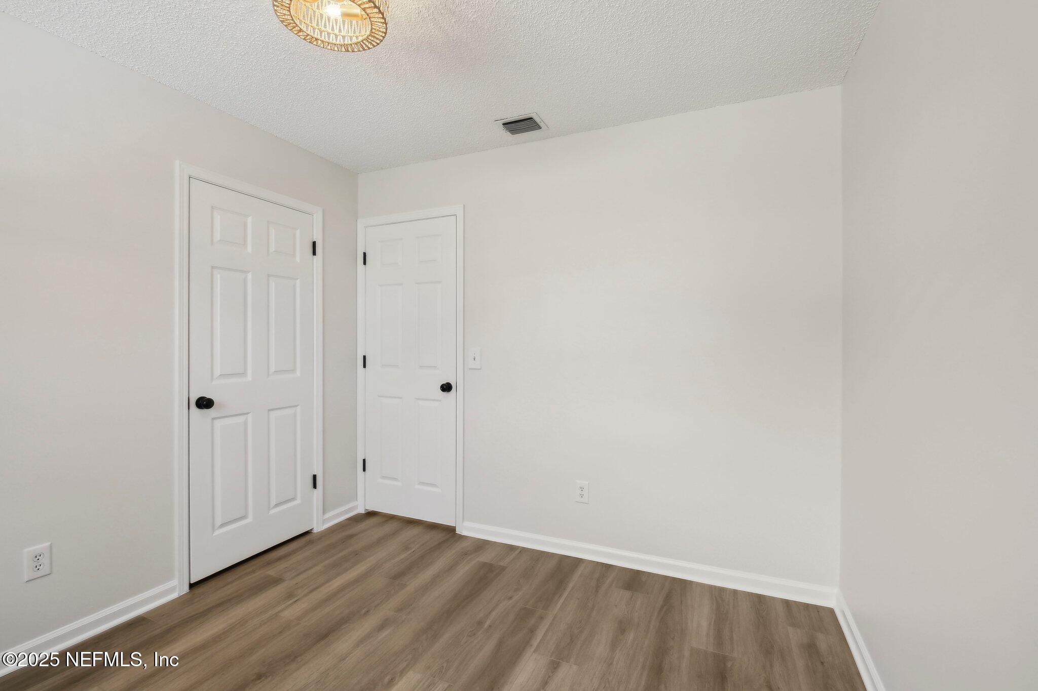 8138 Westport Road Jacksonville, FL 32244 - Photo 15 of 45 a view of an empty room with wooden floor and windows