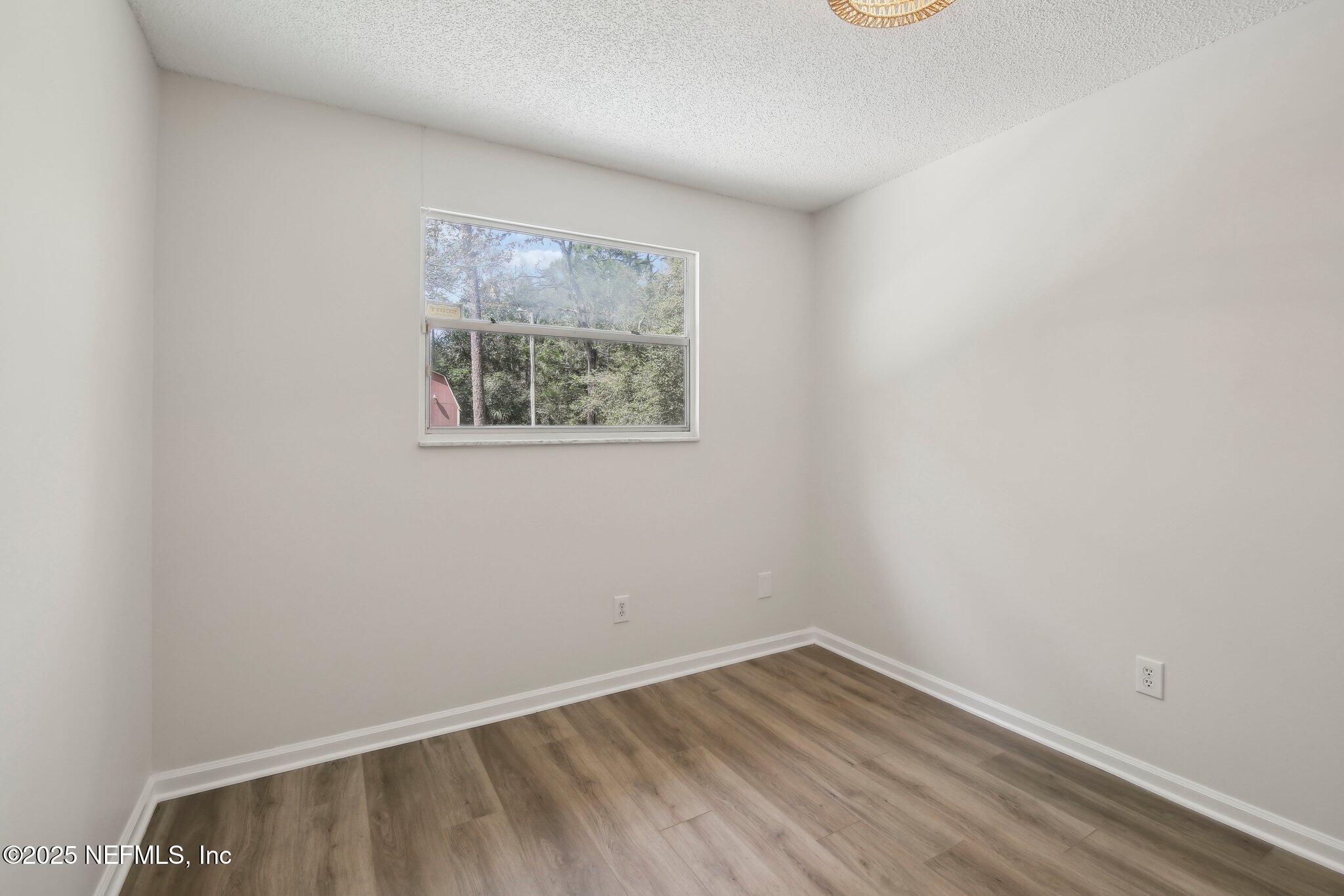 8138 Westport Road Jacksonville, FL 32244 - Photo 16 of 45 a view of an empty room with wooden floor and a window