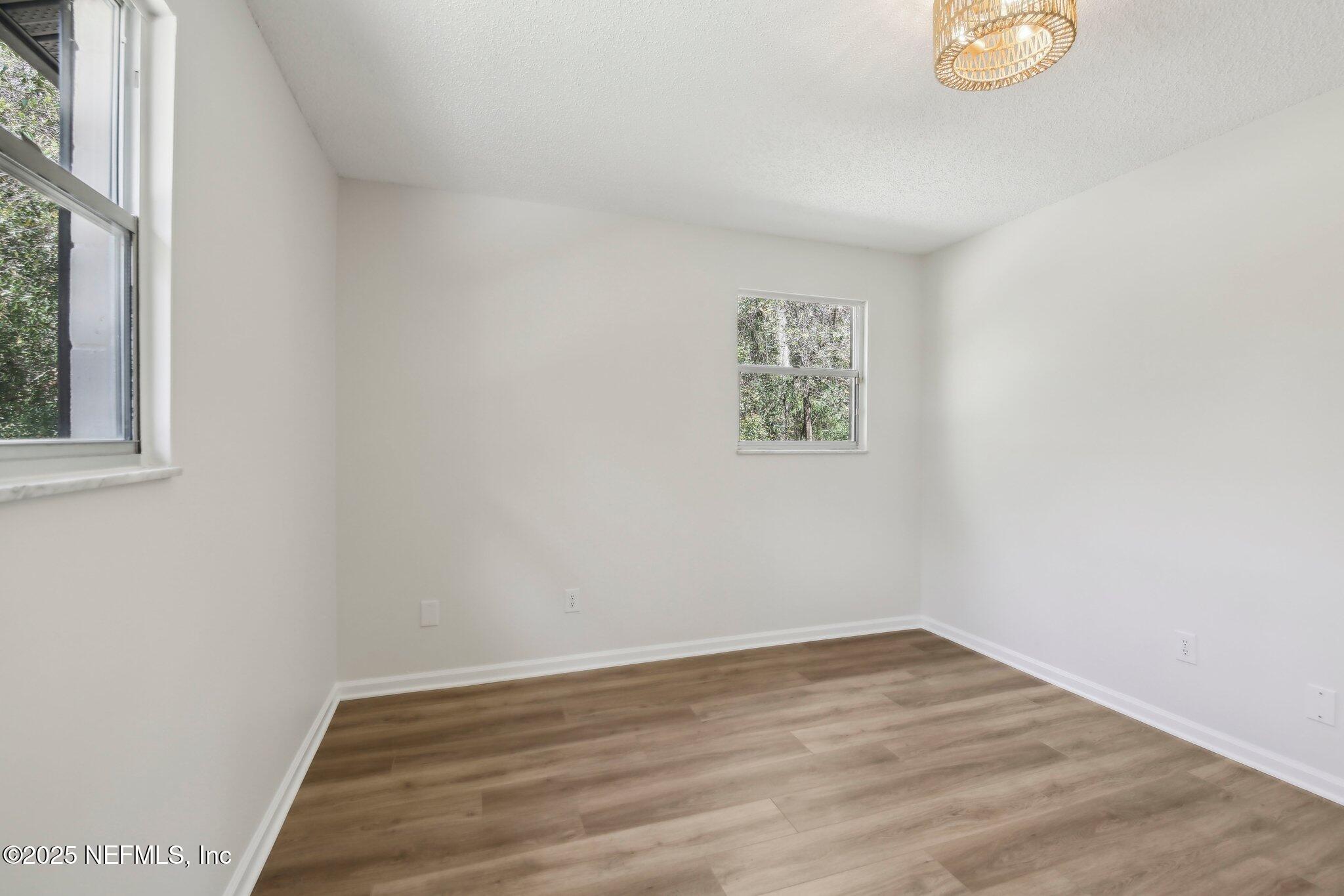 8138 Westport Road Jacksonville, FL 32244 - Photo 20 of 45 a view of an empty room with wooden floor and a window