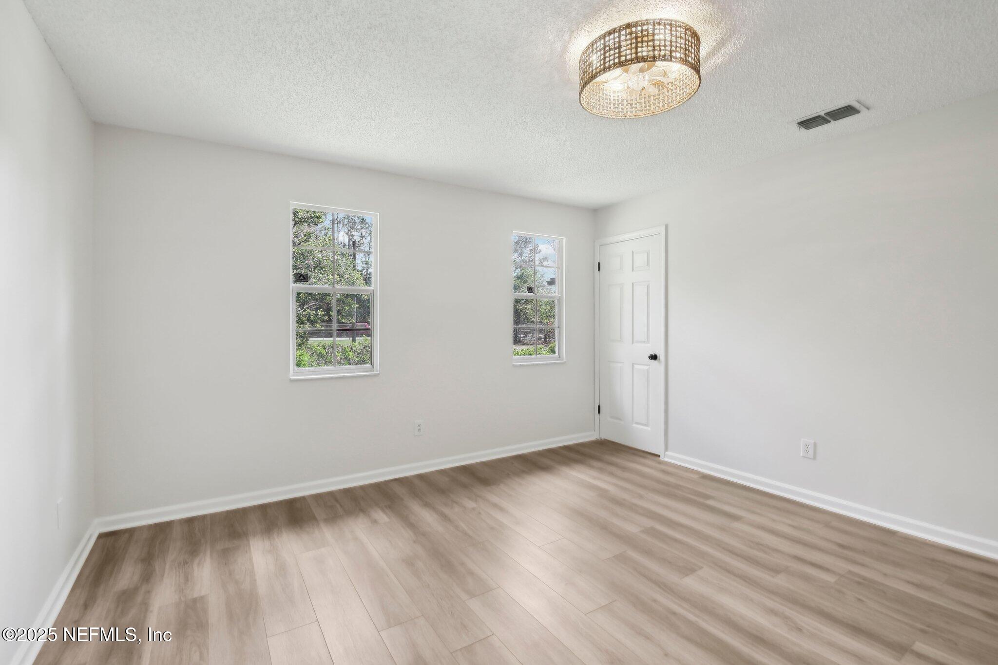 8138 Westport Road Jacksonville, FL 32244 - Photo 24 of 45 an empty room with wooden floor fan and windows