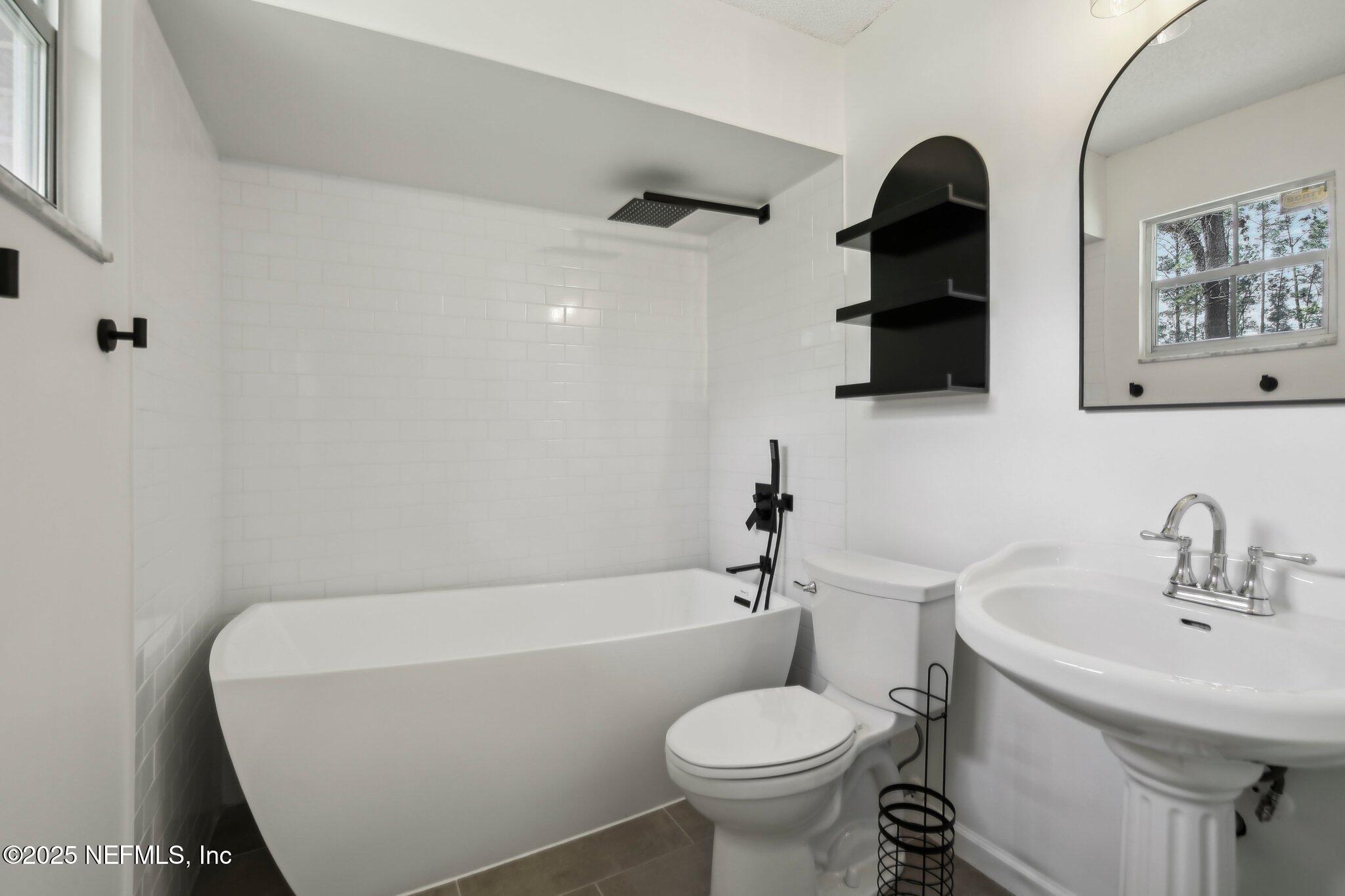 8138 Westport Road Jacksonville, FL 32244 - Photo 25 of 45 a bathroom with a sink a toilet and bathtub