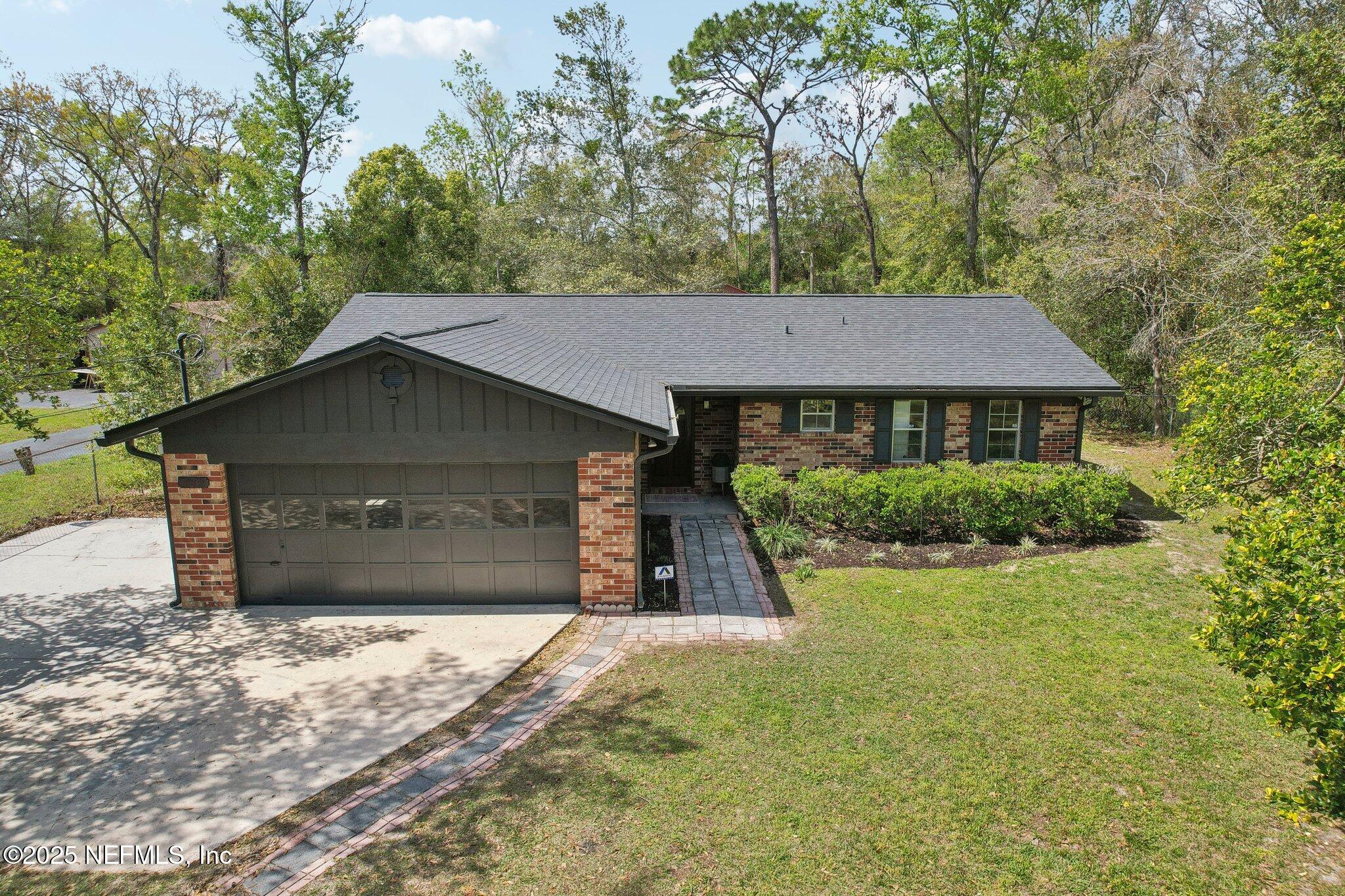 8138 Westport Road Jacksonville, FL 32244 - Photo 36 of 45 a front view of a house with a yard and garage
