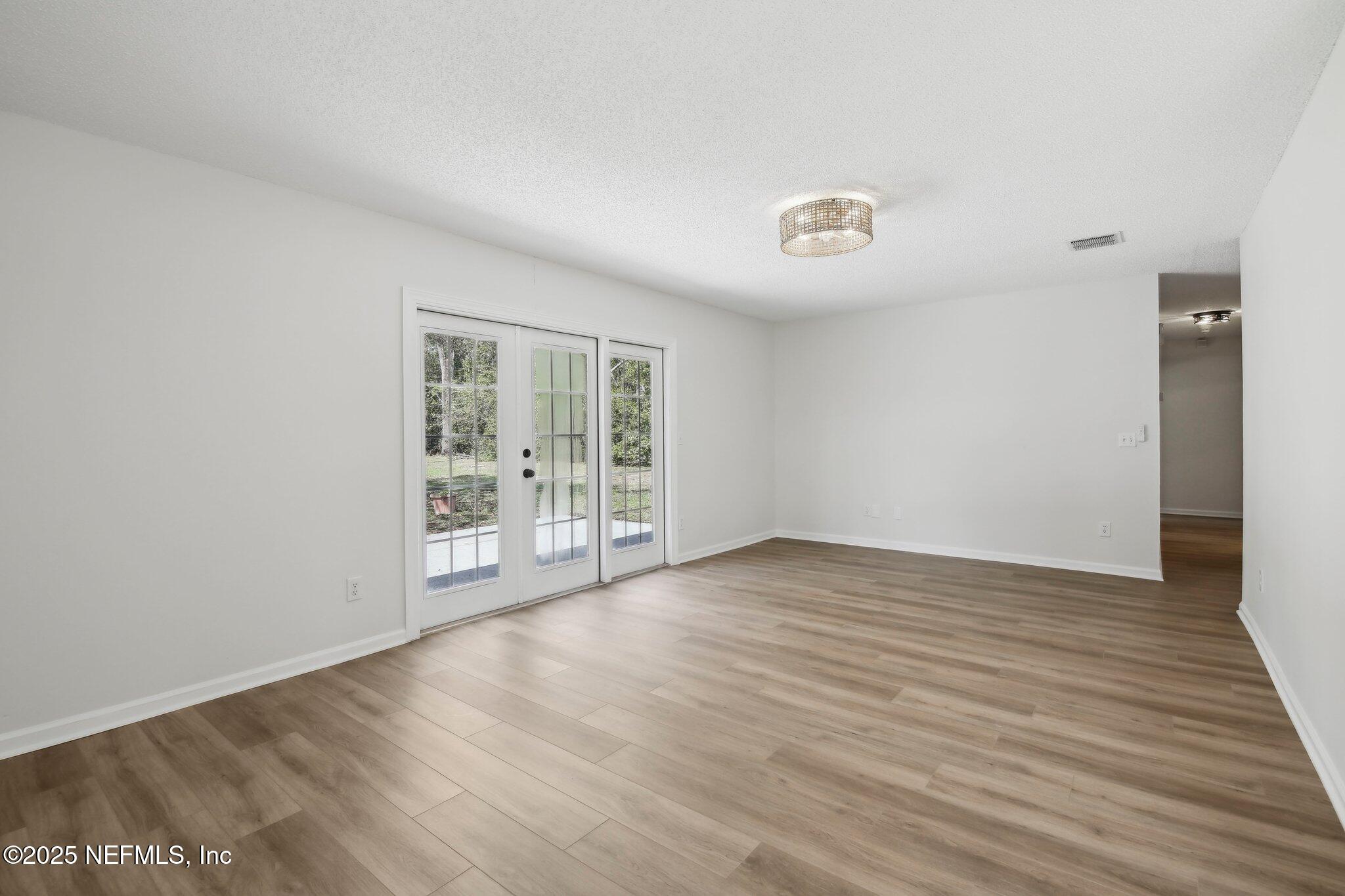8138 Westport Road Jacksonville, FL 32244 - Photo 4 of 45 a view of an empty room with wooden floor and a window