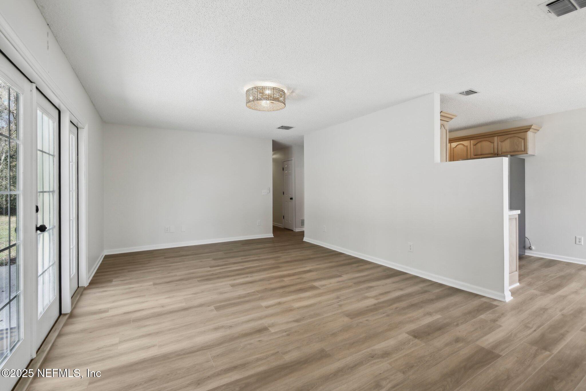 8138 Westport Road Jacksonville, FL 32244 - Photo 5 of 45 a view of an empty room with wooden floor
