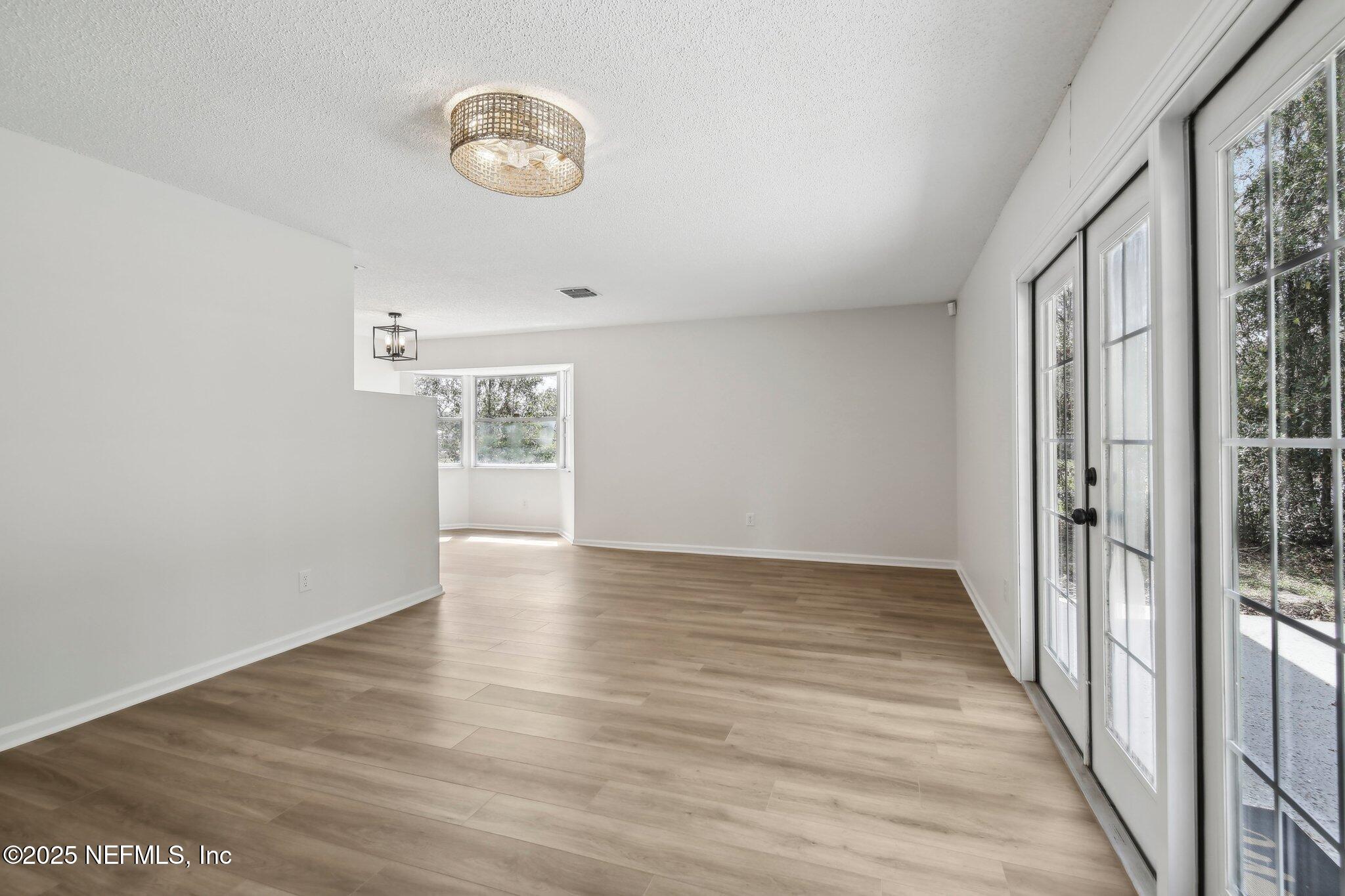 8138 Westport Road Jacksonville, FL 32244 - Photo 6 of 45 a view of an empty room with wooden floor and a window