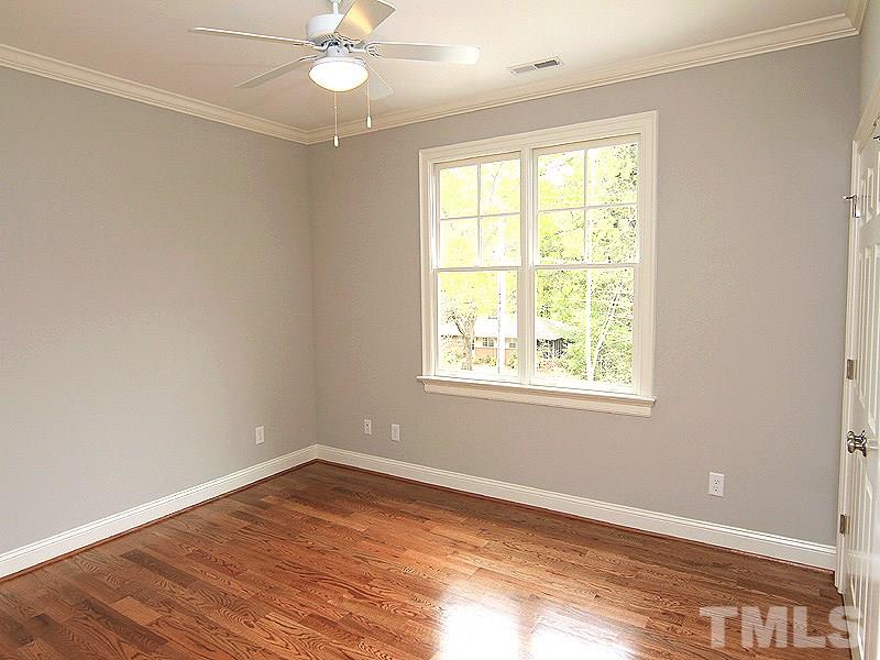3341 Hampton Road Raleigh, NC 27607 - Photo 22 of 25 an empty room with wooden floor chandelier fan and windows