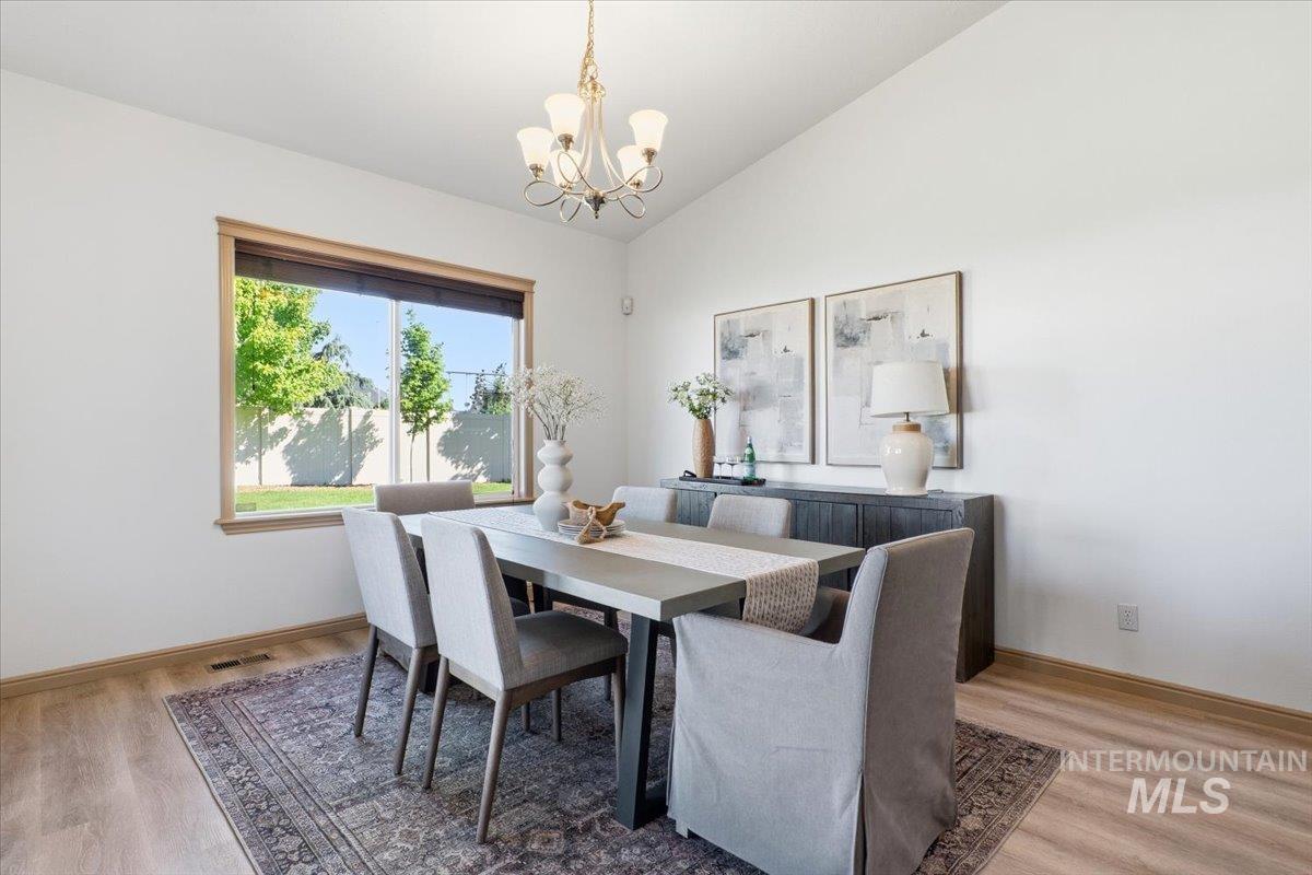 1183 North Buffalo Way Middleton, ID 83644 - Photo 15 of 47 Dining space featuring vaulted ceilings, wood-finish flooring, and a large window with natural wood trim