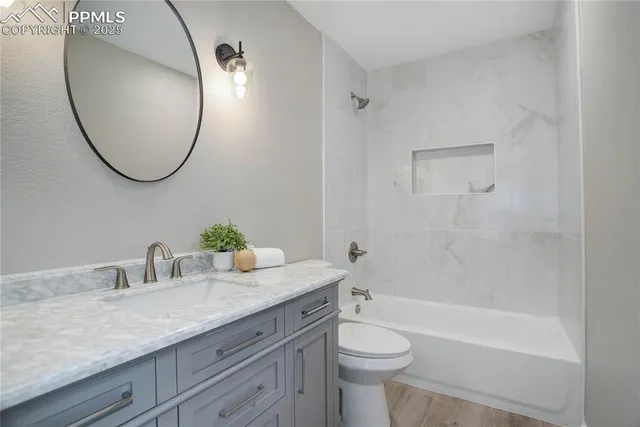 a bathroom with a granite countertop sink mirror toilet and bathtub