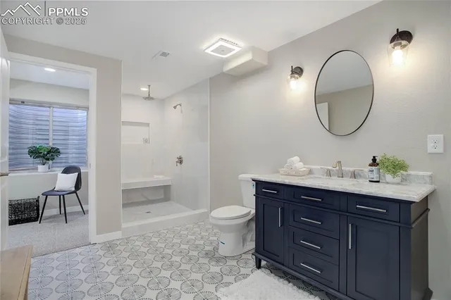 a spacious bathroom with a toilet a sink a mirror and a shower