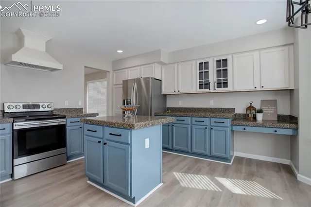 a kitchen with stainless steel appliances granite countertop a stove a sink and a refrigerator