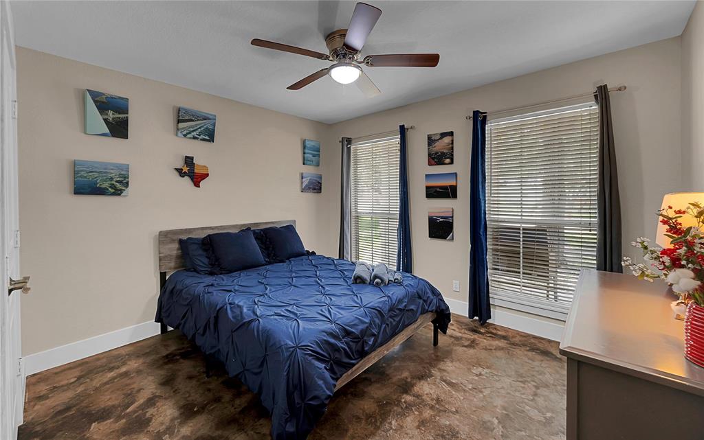 37 Bluebonnet Loop Morgan's Point Resort, TX 76513 - Photo 23 of 38 Bedroom featuring wood-finish flooring, two windows with blinds and curtain rods, and a ceiling fan with light fixture