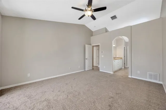 an empty room with chandelier fan