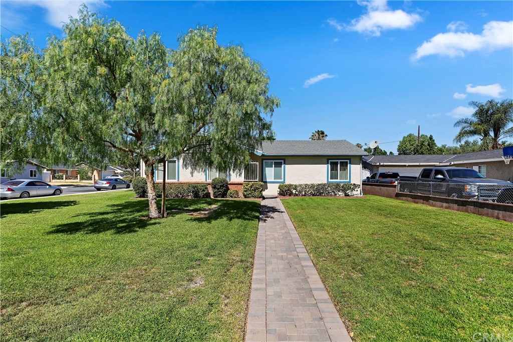 6769 Rutland Avenue Riverside, CA 92503 - Photo 1 of 1 a front view of a house with garden and trees