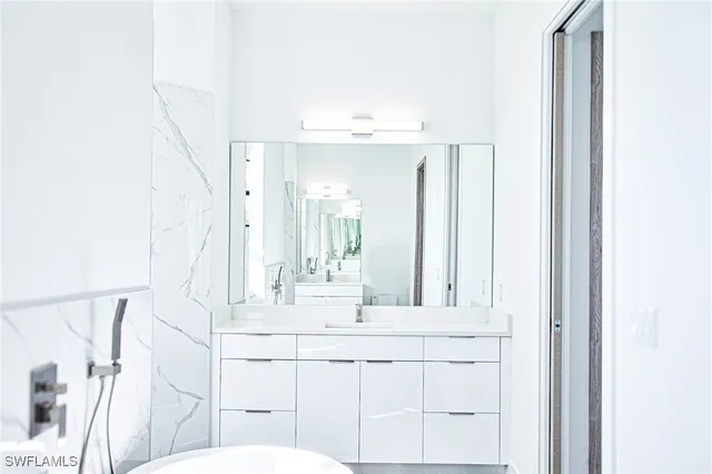 a bathroom with a sink vanity and mirror