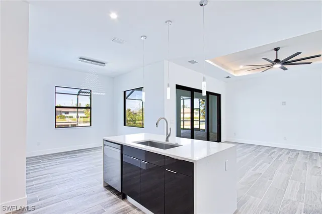 a kitchen with stainless steel appliances granite countertop a sink cabinets and wooden floor