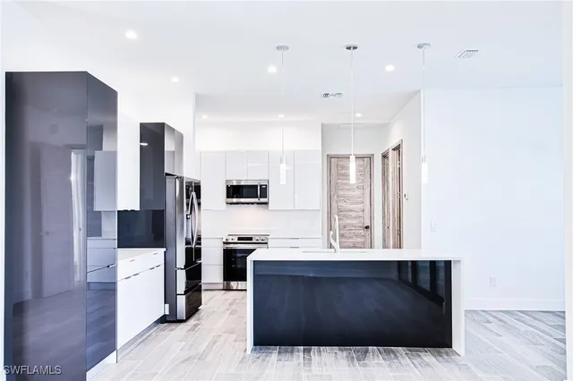 a kitchen with stainless steel appliances a refrigerator and a stove top oven
