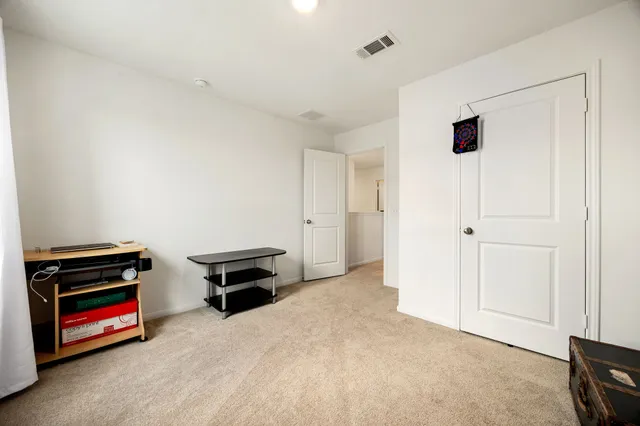 a view of an empty room with furniture and a window
