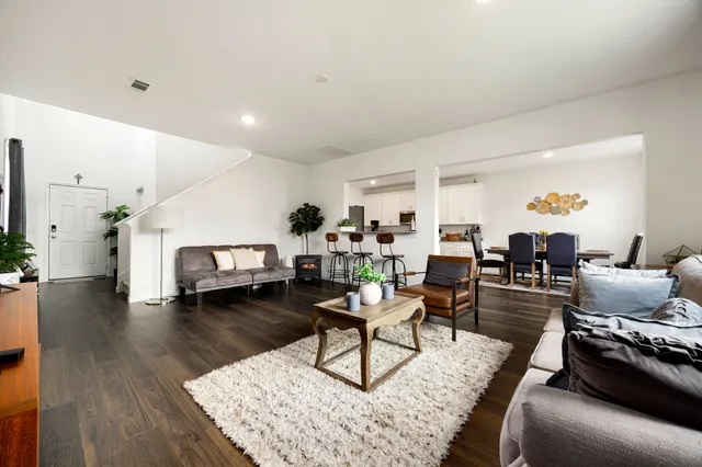 a living room with furniture and a wooden floor