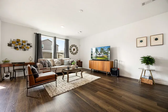 a living room with furniture and a wooden floor