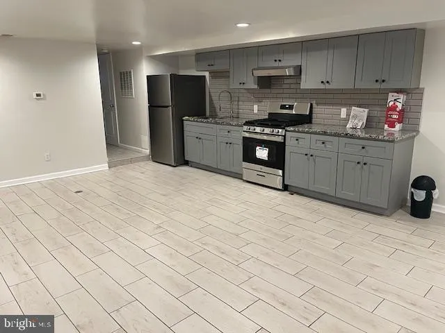 a kitchen with stainless steel appliances kitchen island granite countertop a sink and cabinets