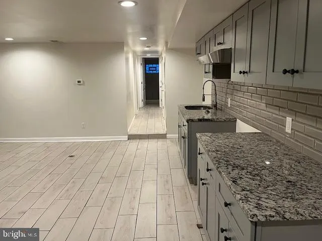 a kitchen with granite countertop a stove a sink and a microwave