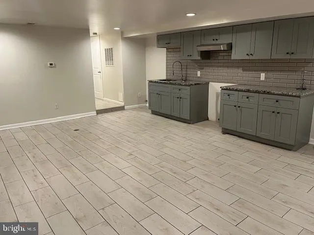 a large kitchen with stainless steel appliances granite countertop a sink and cabinets