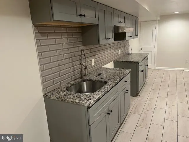 a kitchen with granite countertop a sink and cabinets
