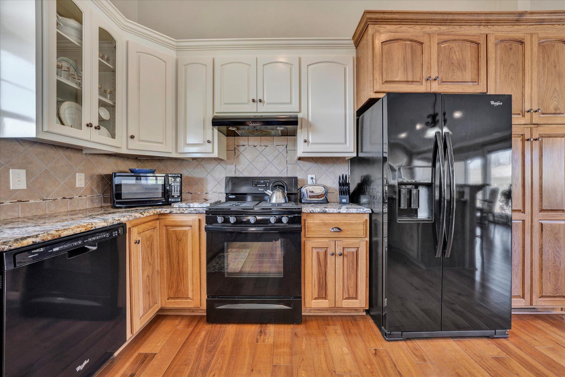 1015 Green Level Road Boones Mill, VA 24065 - Photo 23 of 51 a kitchen with stainless steel appliances granite countertop a refrigerator a stove and a sink with wooden cabinets