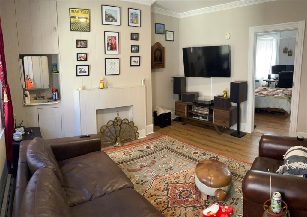 7 Johnny Court, Unit 1 Boston, MA 02111 - Photo 1 of 8 a living room with furniture and a flat screen tv