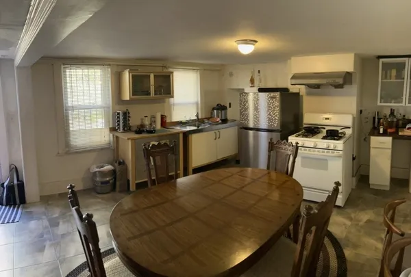 a kitchen with a table chairs refrigerator and microwave