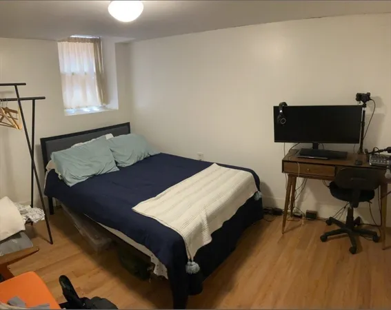a bedroom with a bed window and a desk