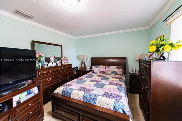 a bedroom with bed and flat screen tv