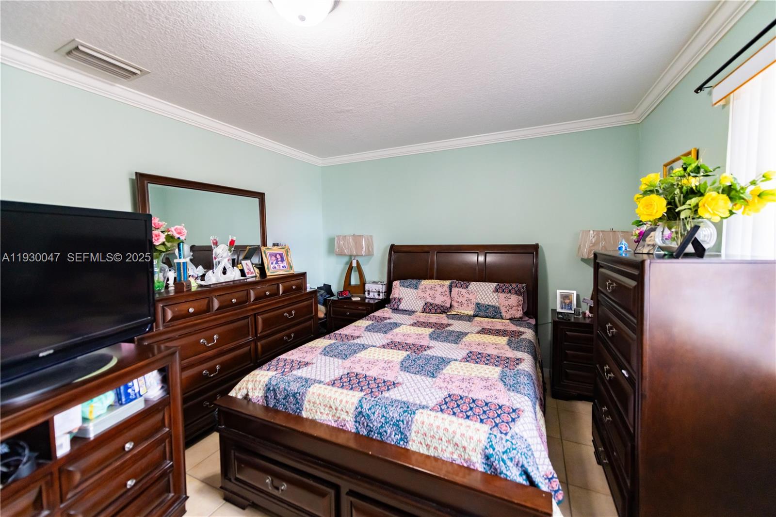 63 Northwest 17th Place, Unit 6 Miami, FL 33125 - Photo 18 of 25 a bedroom with a bed dresser and a flat screen tv