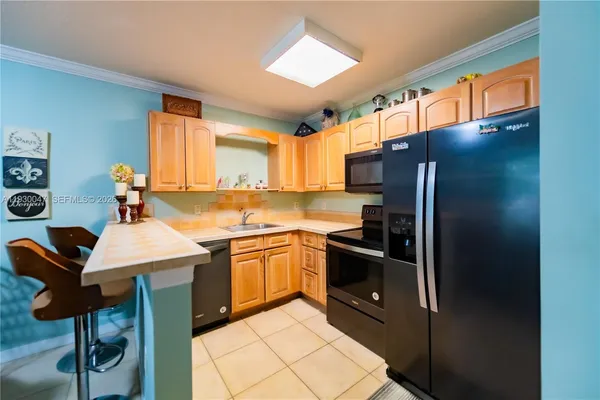 a kitchen with stainless steel appliances granite countertop a sink refrigerator and cabinets