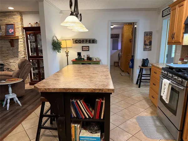 a kitchen with stainless steel appliances granite countertop a stove a refrigerator a dining table and chairs with wooden floor