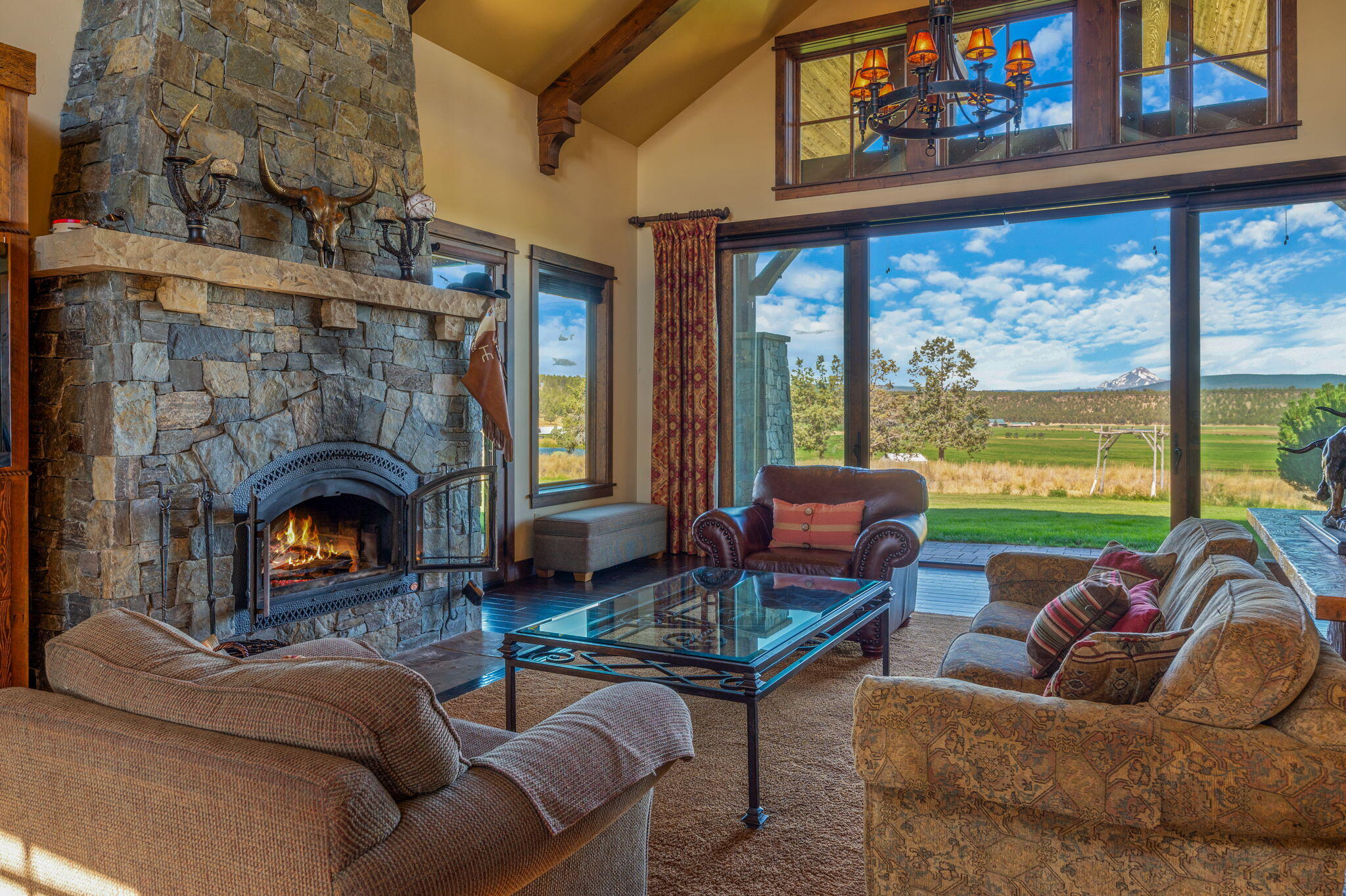 71285 Holmes Road Sisters, OR 97759 - Photo 7 of 123 a living room with furniture a fireplace and floor to ceiling windows