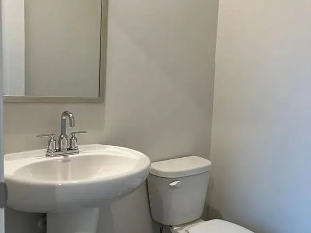 a bathroom with a sink toilet and a mirror