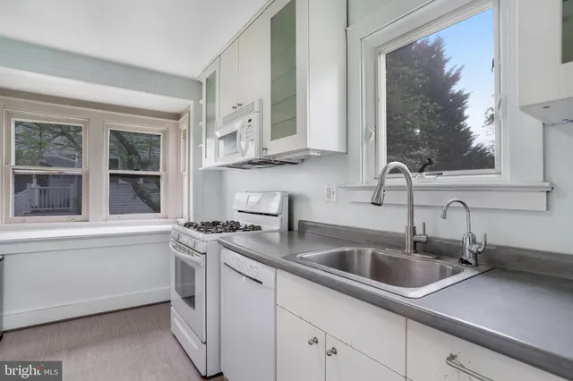 a kitchen with stainless steel appliances a sink a stove and a window