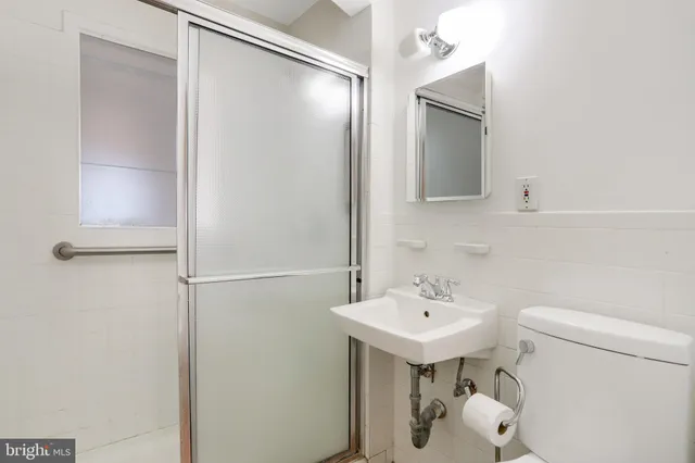 a bathroom with a sink toilet and mirror