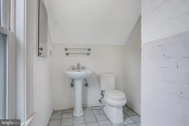 a bathroom with a sink toilet and a mirror