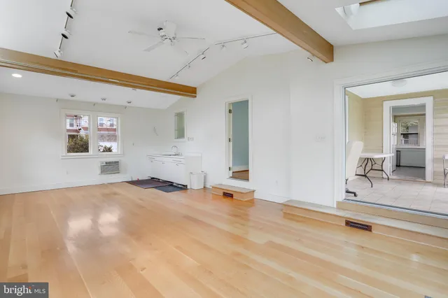 a view of a livingroom with wooden floor and a flat screen tv