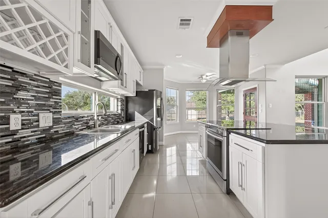 a large kitchen with stainless steel appliances granite countertop a stove and a sink