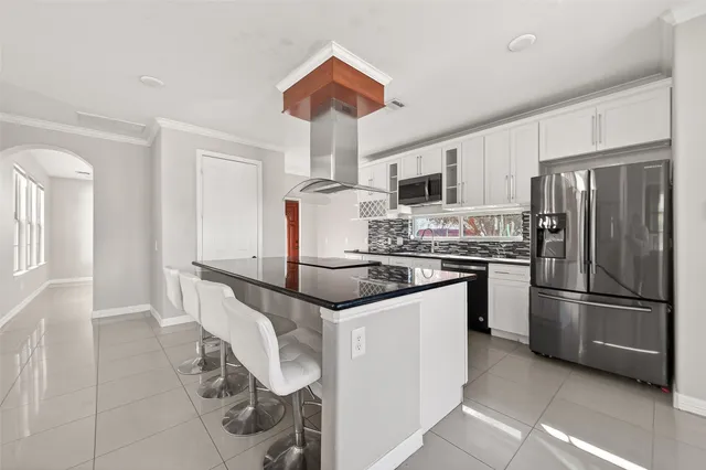 a kitchen with stainless steel appliances granite countertop a refrigerator a stove a sink dishwasher and a refrigerator with wooden floor