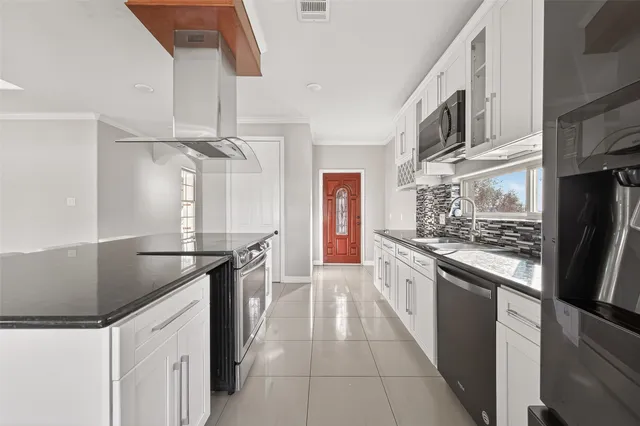 a kitchen with stainless steel appliances granite countertop a refrigerator and a stove