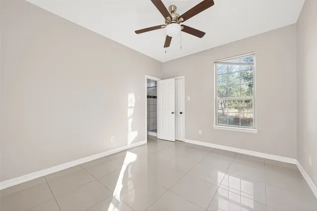 an empty room with a ceiling fan and carpet