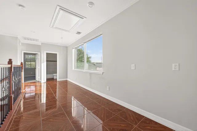 an empty room with windows and fan