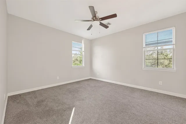 an empty room with a ceiling fan and a window