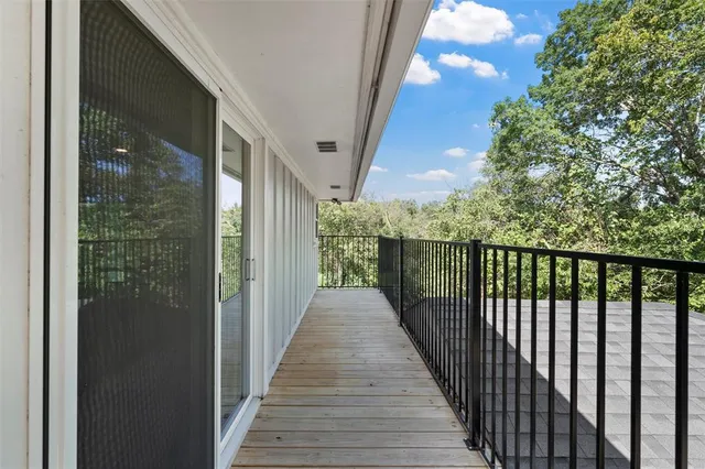 a open kitchen with granite countertop a stove top oven a chimney cabinets and wooden floor