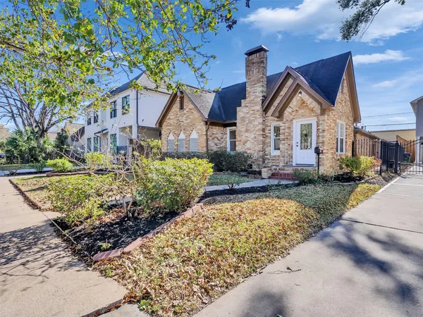 a front view of a house with a yard and potted plants