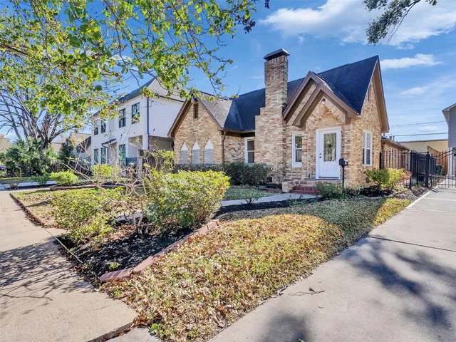 a front view of a house with a yard and potted plants